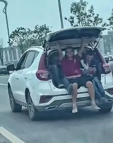 猖狂！宜宾一辆行驶途中的小车，3人挤在后备箱拿手机自拍！-3.png